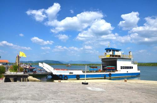 a ferry boat is docked at a dock at The Sunset Beach Resort - Koh Kho Khao in Ko Kho Khao