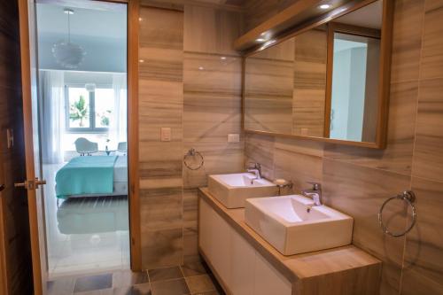 uma casa de banho com 2 lavatórios e um espelho em Sea Winds with Direct Ocean Views em Cabarete