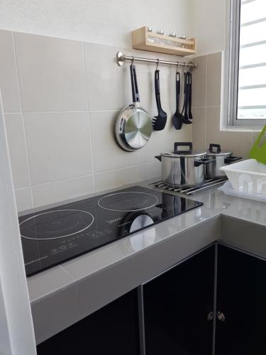 a kitchen with a stove top oven in a kitchen at HZ Homestay @Ascotte Boulevard in Semenyih