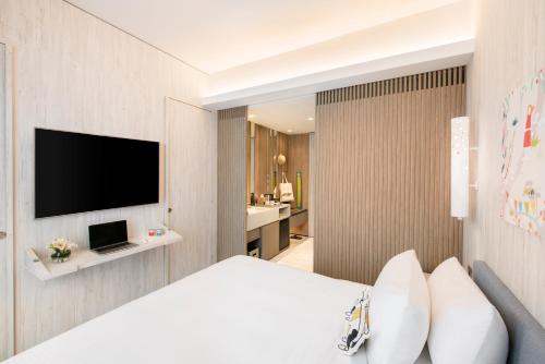a hotel room with a bed and a flat screen tv at Village Hotel Sentosa by Far East Hospitality in Singapore