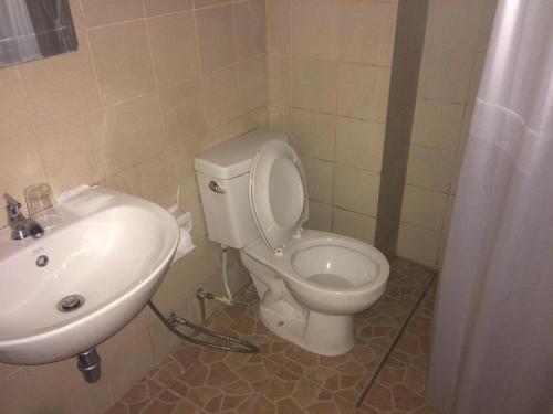 uma casa de banho com um WC e um lavatório em Pin Hotel em Lampang