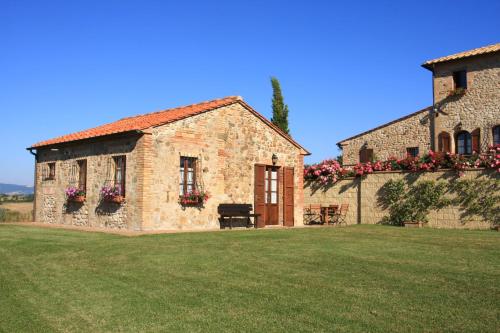 a stone house with flowers on the side of it at Agriturismo Ragoncino in Laiatico