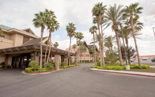 a street in front of a resort with palm trees at Suites at Tahiti Village Resort and Spa-No Resort Fee in Las Vegas