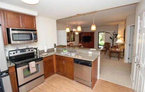 a kitchen with stainless steel appliances and a living room at Suites at Tahiti Village Resort and Spa-No Resort Fee in Las Vegas