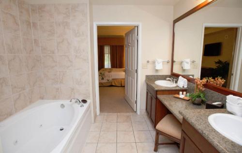 y baño con bañera y 2 lavabos. en Suites at Tahiti Village Resort and Spa-No Resort Fee, en Las Vegas