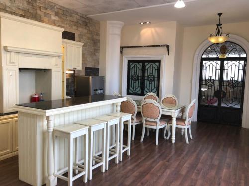 a kitchen with a counter and a table and chairs at Bideco Hotel in Thu Dau Mot