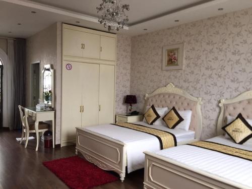 um quarto com 2 camas, uma mesa e uma secretária em Bideco Hotel em Thu Dau Mot