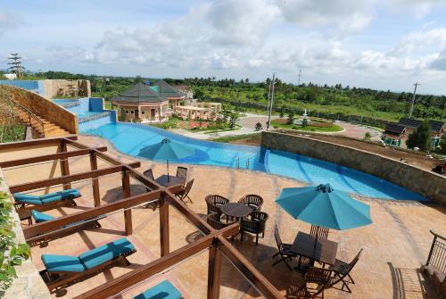 a view of a swimming pool with tables and umbrellas at Summit Ridge Tagaytay - Newly Renovated in Tagaytay
