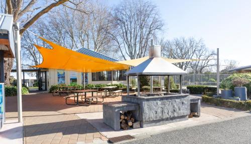 a building with a large umbrella and tables and benches at Hastings TOP 10 Holiday Park in Hastings