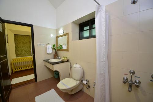 a bathroom with a toilet and a sink and a shower at Hotel Treetop in Thekkady