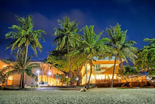 タオ島にあるAnanda Villa - SHA Plusの夜のビーチでヤシの木が植わるリゾート