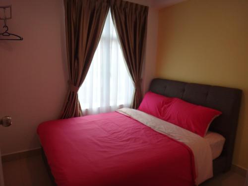 a bedroom with a pink bed with a window at Famosa 2 Stay in Melaka