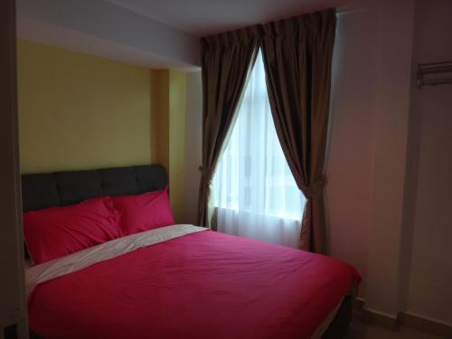 a bedroom with a red bed and a window at Famosa 2 Stay in Melaka