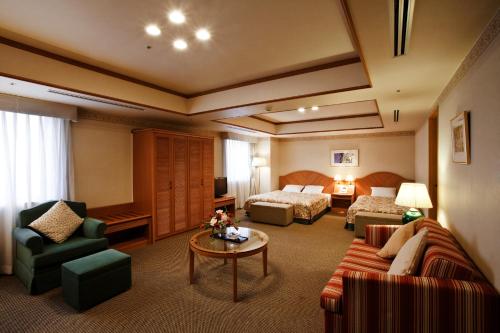 a hotel room with a bed and a living room at Hotel Mielparque Nagoya in Nagoya