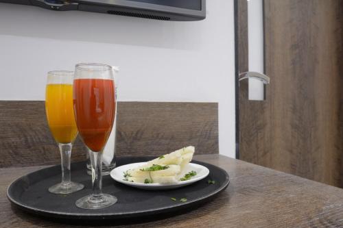 a plate of food and two drinks on a table at Hotel One Up in Ahmedabad