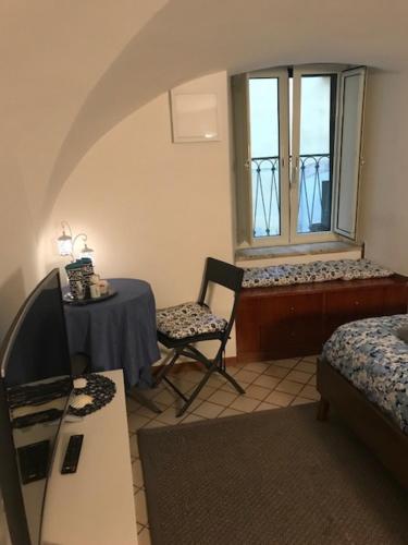 サレルノにあるTana del Papaのテーブルと椅子、窓が備わる客室です。