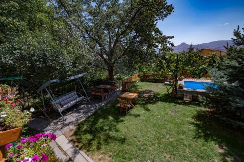 a yard with benches and a swimming pool at Green Stone Boutique Hotel in Yeghegnadzor