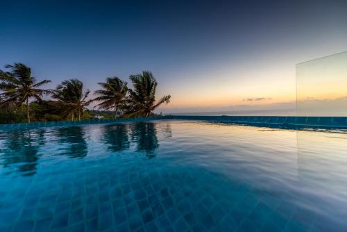 a swimming pool with a view of the ocean at Agnus Unawatuna in Unawatuna