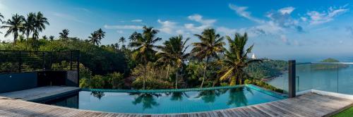 a swimming pool in a resort with palm trees at Agnus Unawatuna in Unawatuna
