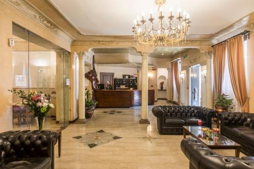 a large living room with leather furniture and a chandelier at Hotel Villa Rosa in Rome