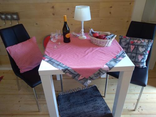 a table with a bottle of wine and a basket of fruit at Petra's Urlaubshüttn in Hermagor