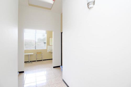 an empty room with a table and a window at RedDoorz Near PRPP Marina Semarang in Kalibanteng-lor