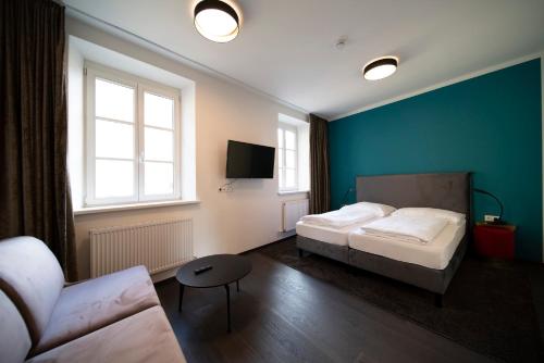 a hotel room with two beds and a couch at Blackhome Innsbruck Boutique I contactless check-in in Innsbruck