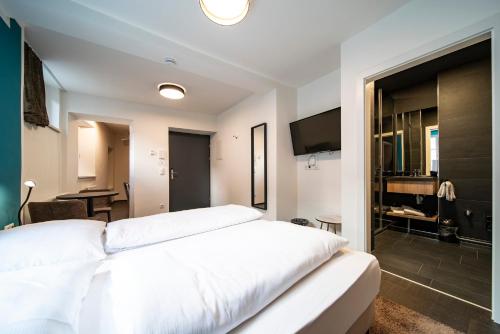 a bedroom with a large white bed and a television at Blackhome Innsbruck Boutique I contactless check-in in Innsbruck