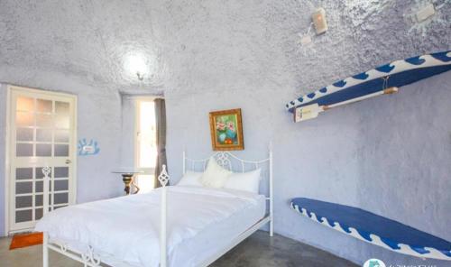 a bedroom with a bed and a surfboard on the wall at Kenting Ha-Bi Star Fort in Hengchun