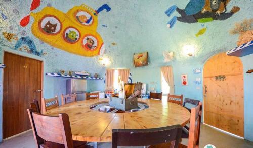 a dining room with a large wooden table and a room with a ceiling decorated with at Kenting Ha-Bi Star Fort in Hengchun