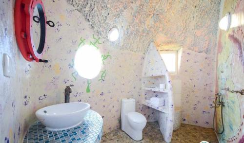 a bathroom with a white sink and a toilet at Kenting Ha-Bi Star Fort in Hengchun