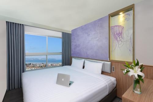 a bedroom with a bed with a laptop on it at Centre Point Prime Hotel Pattaya in Pattaya North