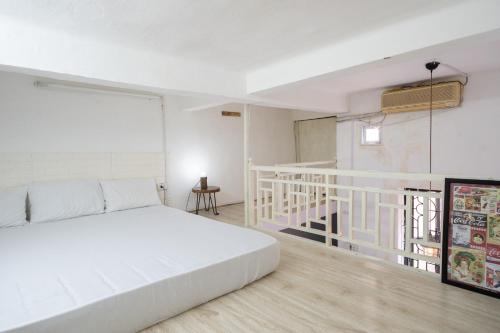 a bedroom with a white bed and a staircase at Old Quarter Apartment Hang Bo in Hanoi