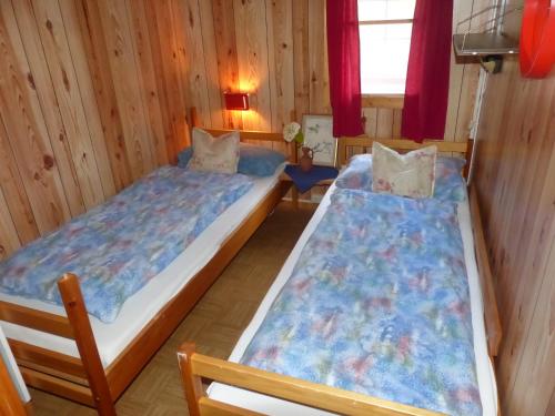 2 camas en una habitación con paredes de madera en Visit Wilderness en Åmli