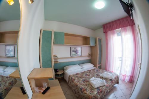 pokój hotelowy z dwoma łóżkami i lustrem w obiekcie Hotel Angelini w Rimini