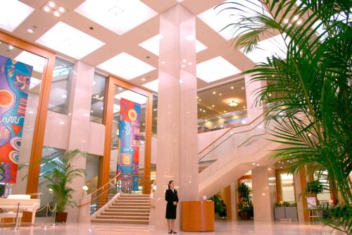 a woman standing in the lobby of a shopping mall at Hotel Mielparque Nagoya in Nagoya