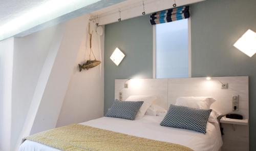 a bedroom with a white bed with blue and white pillows at Le Mas des Citronniers in Collioure