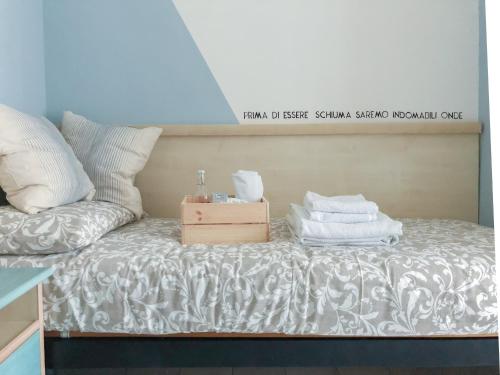a bed with white sheets and a box on it at Alba B&B in Cattolica