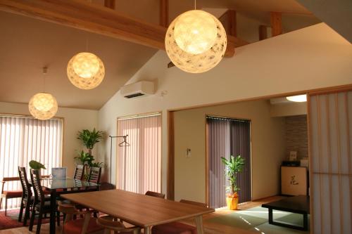 a dining room with a table and some lights at Yakunoyado Taguchi in Yakushima
