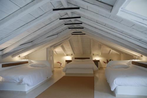 two beds in a room with an attic at Mistral Hotel in Hydra