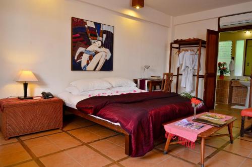a bedroom with a bed with a painting on the wall at Punta Bulata White Beach Resort & Spa in Sipalay