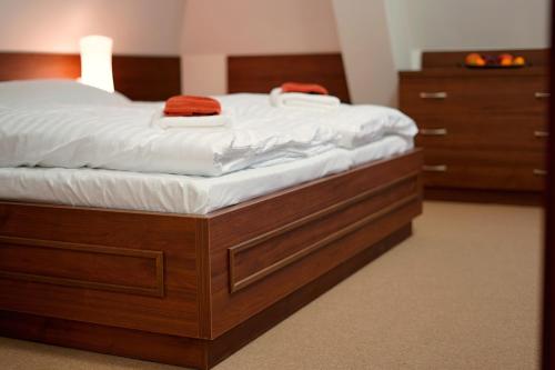 a bed with white sheets and red towels on it at Zámecký Penzion in Valašské Meziříčí