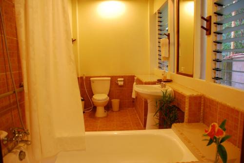 a bathroom with a tub and a toilet and a sink at Punta Bulata White Beach Resort & Spa in Sipalay
