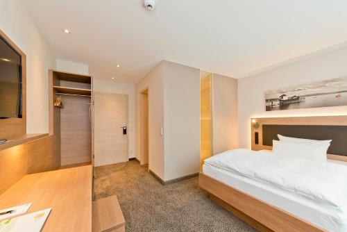a bedroom with a large white bed and a desk at Hotel Bären in Rottweil