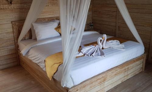 a bedroom with two beds with mosquito nets at Tiki bar and more in Nusa Lembongan