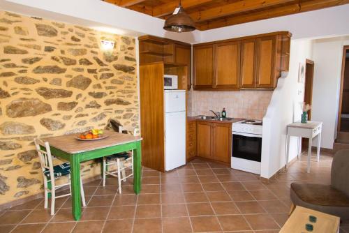 a kitchen with a green table in a room at Agrilos Οlive Τree Αpartment in Mirsíni