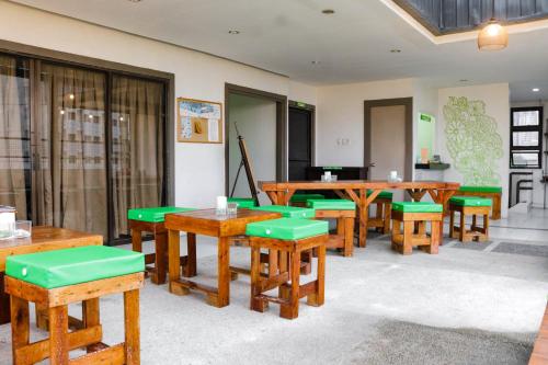 ein Klassenzimmer mit Holztischen und grünen Sitzen in der Unterkunft RedDoorz @ Junquera Extension Cebu in Cebu City