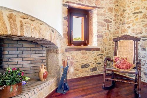 a room with a chair and a brick fireplace at The old cheese hut in Zou