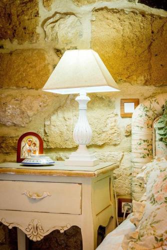 a lamp sitting on a dresser in a bedroom at The old cheese hut in Zou
