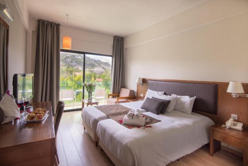 a hotel room with a large bed and a table at Rodon Hotel and Resort in Agros